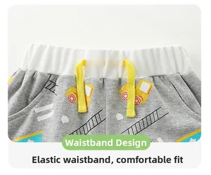 Detail of grey shorts with yellow construction truck print and elastic drawstring waist