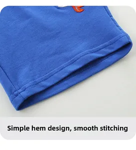 Detail of royal blue cotton shorts showing neat stitching and shark embroidery