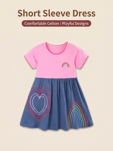 Dettaglio ricamo arcobaleno e cuori su un abito da bambina in cotone rosa e blu scuro
