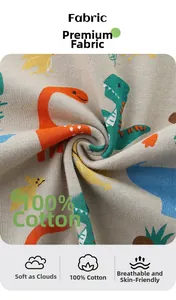 Dettaglio del tessuto in 100% cotone con stampe di dinosauri colorati per t-shirt da bambino