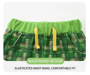 Close-up of boys green checkered shorts with elastic waistband and yellow drawstring