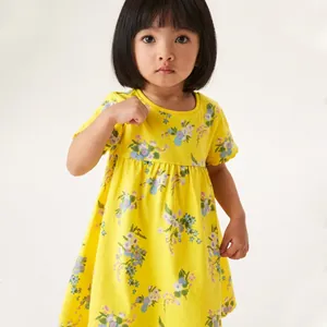 Close-up of yellow girls' summer dress with vibrant blue and green floral prints