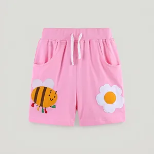 Detail of pink cotton kids shorts with elastic drawstring waist and cute bee patches