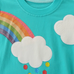 Girls long sleeve teal sweatshirt featuring a sparkling rainbow embroidery and cloud patch