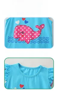 Detail of blue cotton top featuring pink polka dot whale print and ruffled sleeves