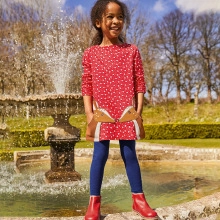 Détail de la robe rouge à pois avec poches renard et pantalon bleu pour enfant en plein air