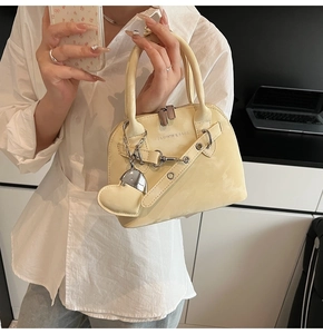 Détail du sac à main beige crème avec imprimé texte et breloque en forme de cœur