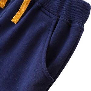 Boys navy blue cotton sweatpants with elastic ribbed waist and yellow drawstring cord