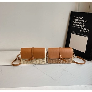 Detailaufnahme von gewebten Strohtaschen mit Lederklappe und goldenem Ringakzent