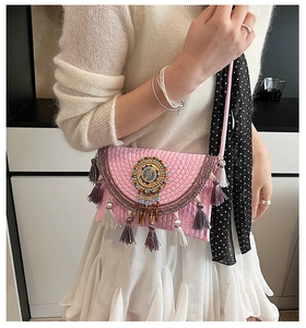 Detail of pink knitted boho bag with colorful bead embroidery and purple tassels
