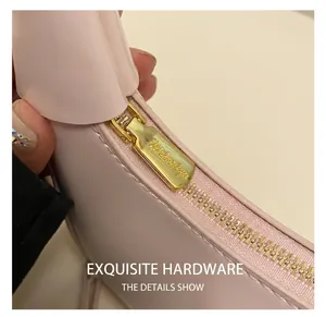 Macro detail of high-quality gold metal zipper and stitching on pink shoulder bag