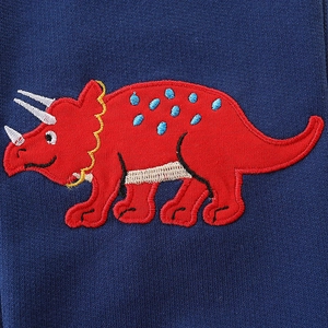 Navy knit boys sweatpants with a vivid red embroidered triceratops dinosaur detail