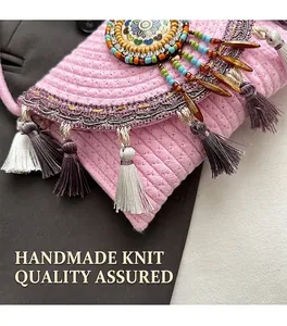 Detailed view of pink woven bohemian bag with colorful tassels and mandala ornament