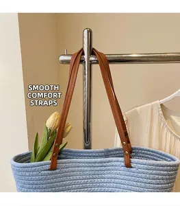 Detail of the blue woven straw tote bag featuring reinforced brown leather shoulder straps