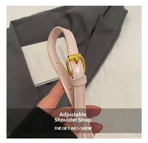 Close-up of pink leather adjustable shoulder strap with gold buckle and fine stitching