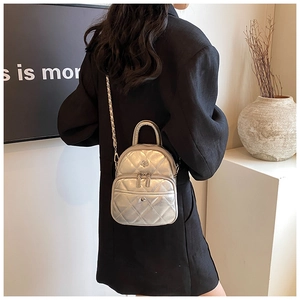 Détail du mini sac matelassé argenté porté en bandoulière avec finition métallique chic