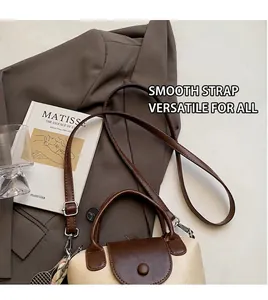 Detail of two-tone crossbody bag featuring a leather flap, handle and tennis racket charm