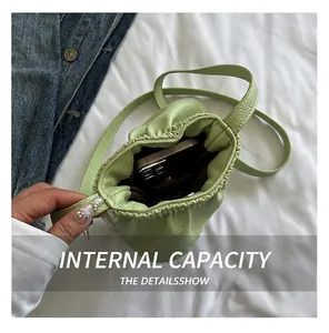 Vue intérieure d'un petit sac seau vert à cordon montrant l'espace pour un portable