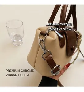 Detailed view of two-tone beige and brown bag with premium silver metal hooks and zippers