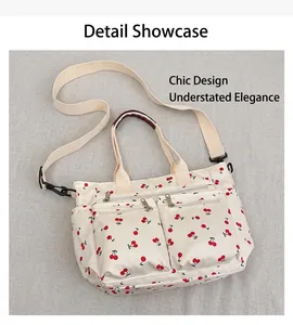 Détail d'un cabas blanc à motif cerises avec poches zippées et bandoulière réglable