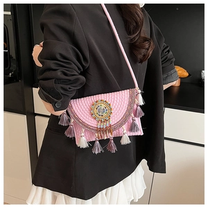 Detail of pink bohemian woven bag with ethnic bead embroidery and colorful tassels