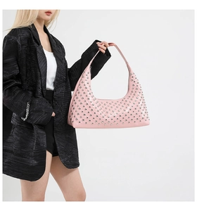 Close-up of pink leather hobo bag featuring dense silver metal stud details and texture