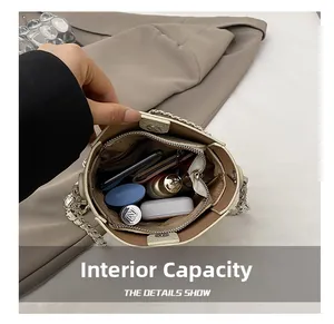 Detail view showing internal capacity of the off-white bucket bag with a zip pocket