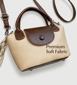 Detail of a contrast color crossbody bag with cream body and dark brown saddle flap