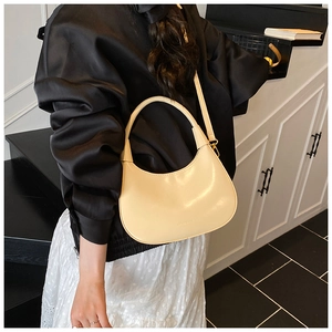 Dettaglio borsa a tracolla beige a mezzaluna in pelle con eleganti ganci in metallo oro