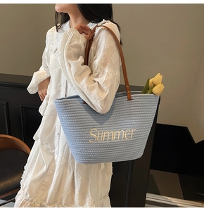 Détail du cabas tissé bleu clair avec broderie Summer et anses en cuir marron