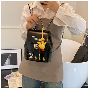 Detail eines schwarzen Mini-Rucksacks mit Silberkette, Rosenschloss und Entenanhänger