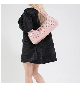 Macro detail of pink patent leather moon bag with silver metallic rivets and glossy finish