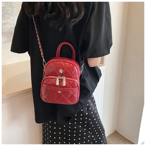 Detailed back view of a red quilted leather mini bag with chain straps on a model