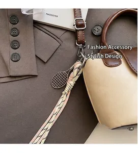 Detail of cream and brown crossbody bag with tennis racket charm and braided rope handle