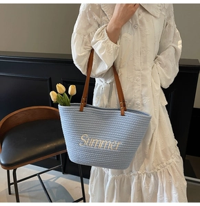 Détail du sac fourre-tout tissé bleu clair avec broderie Summer et anses en cuir