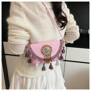 Detailed shot of pink knit crossbody bag featuring colorful beads and long fringe tassels