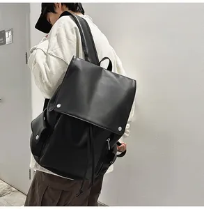 Detail of black leather backpack with silver metal buckles and large flap closure