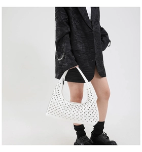 Detail of white PU leather hobo bag featuring silver rivets and Y2K crescent shape design