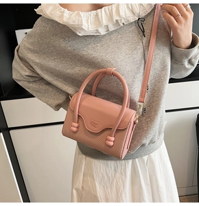 Détail du mini sac à bandoulière rose avec tissage texturé et bandoulière en cuir