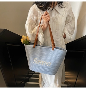 Détail du sac de plage tressé avec broderie Summer et poignées en cuir marron