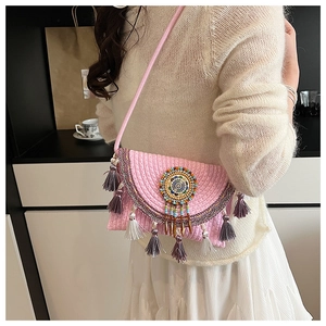 Close-up detail of pink crochet crossbody bag featuring colorful beadwork and purple tassels