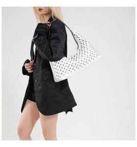 Close-up of white semi-circle shoulder bag with silver metal studs and sleek leather