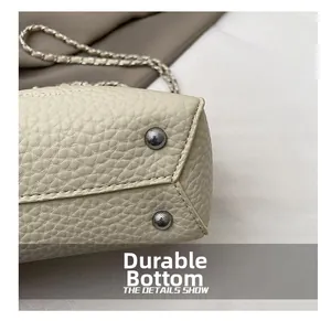 Detailed close-up of wear-resistant metal feet on beige pebble leather bucket bag