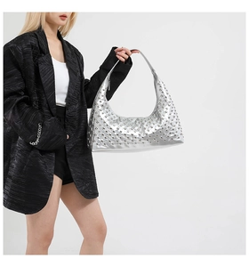 Close-up of silver hobo bag with metallic studs and polished mirror finish texture