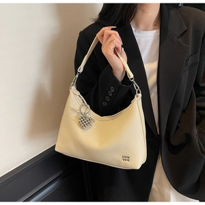 Detailed texture of off-white lychee pattern leather on a crescent crossbody bag
