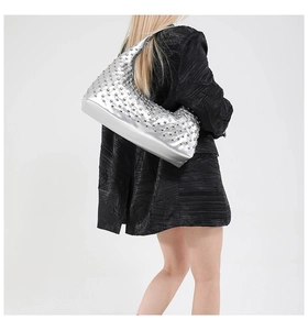 Silver metallic Hobo bag with studs worn by model showing style and size