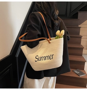 Détail du sac cabas tissé crème avec broderie Summer et anses en cuir marron
