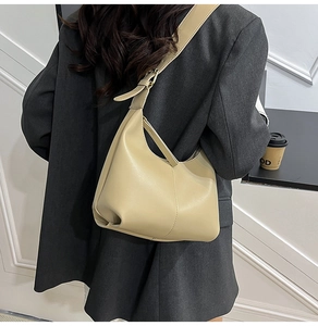 Detail view of stylish beige hobo shoulder bag with matte leather texture and metal buckle