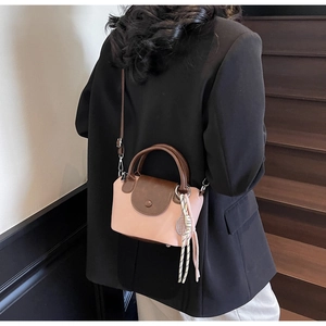 Detail of pink and brown leather mini crossbody bag with a tennis racket charm
