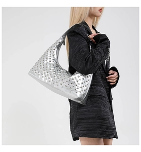 Detail view of silver punk tote bag featuring metallic rivets and stylish hobo silhouette